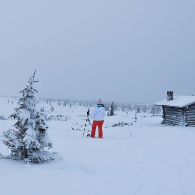 Snowshoeing between cabins and pines is a great way to explore Finnish Lapland