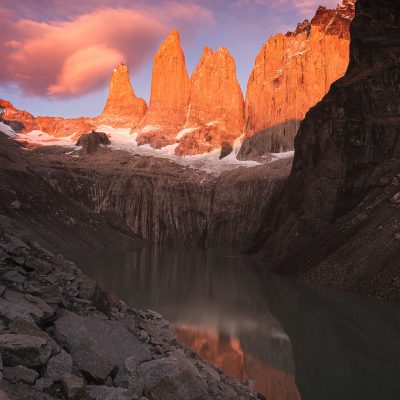 The first rays of the Sun painting with red color Las Torres del Paine at sunrise